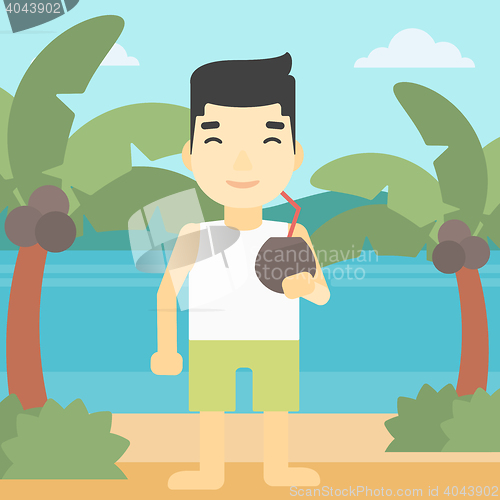 Image of Man drinking coconut cocktail on the beach.