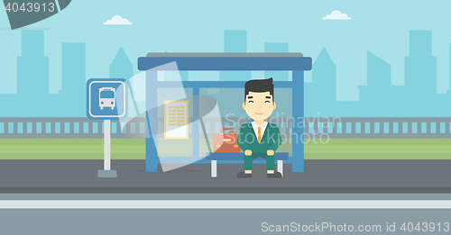 Image of Man waiting for bus at the bus stop.