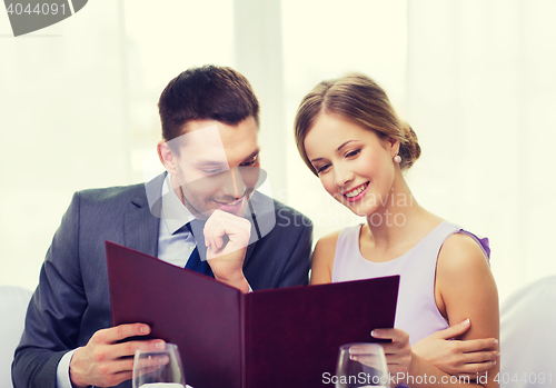 Image of smiling couple with menu at restaurant