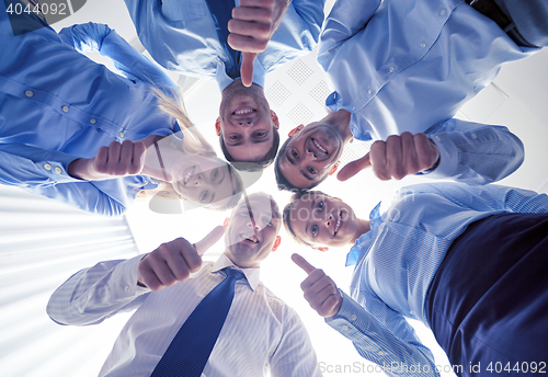 Image of smiling group of businesspeople standing in circle