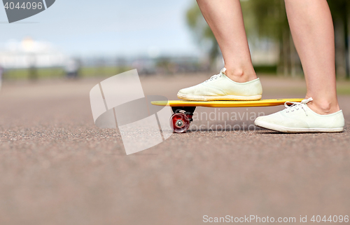 Image of close up of female feet riding short skateboard