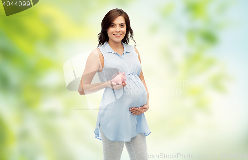 Image of happy pregnant woman with piggybank