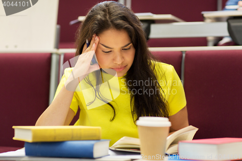 Image of student girl with books and coffee on lecture