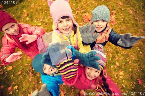 Image of happy children waving hands in autumn park