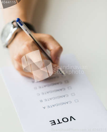 Image of close up of hands with vote or ballot on election