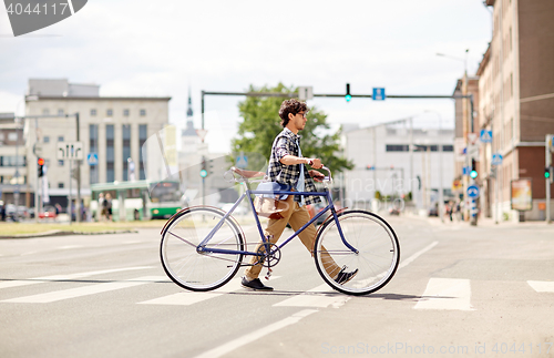 Image of young man with fixed gear bicycle on crosswalk