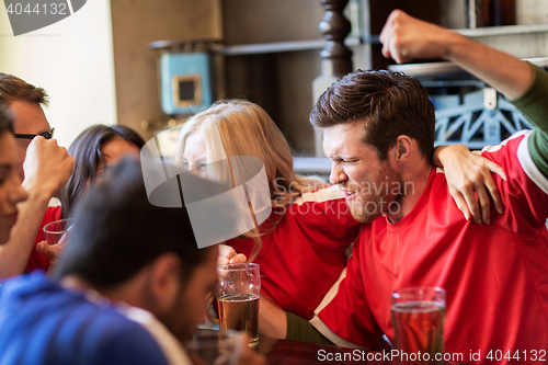 Image of football fans or friends with beer at sport bar