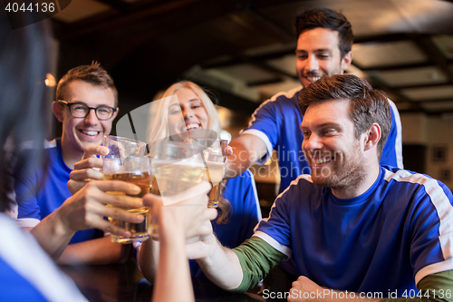 Image of football fans clinking beer glasses at sport bar