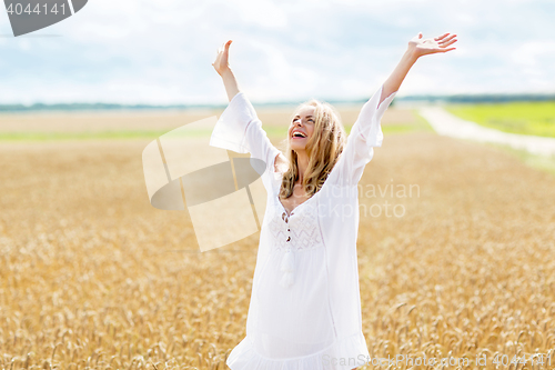 Image of smiling young woman in white dress on cereal field