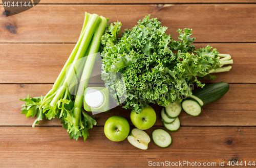 Image of close up of bottle with green juice and vegetables