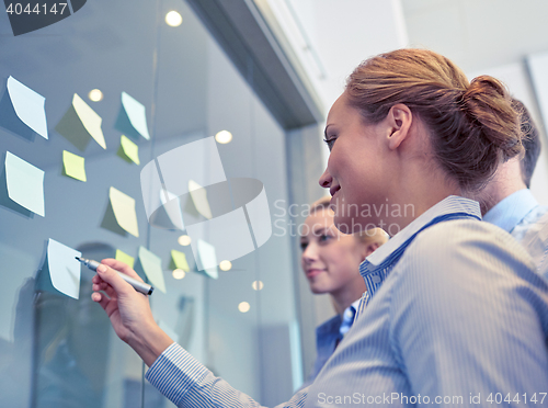 Image of smiling business people with marker and stickers