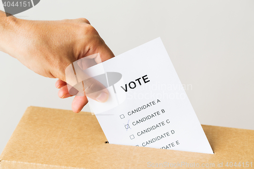 Image of man putting his vote into ballot box on election