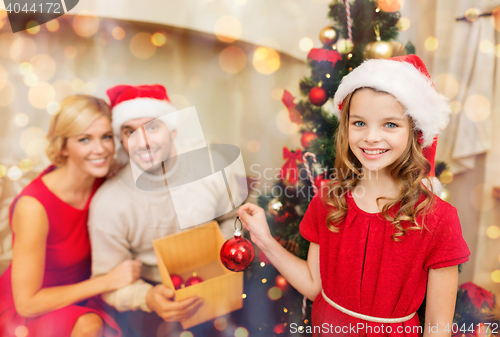 Image of smiling family decorating christmas tree