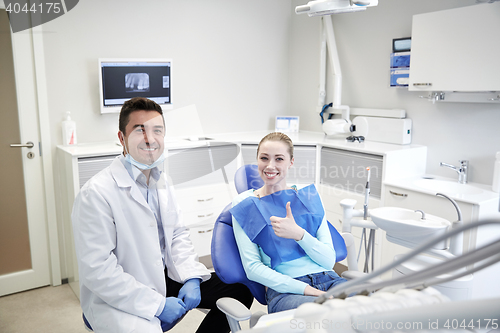 Image of happy male dentist with woman patient at clinic