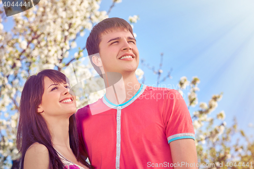 Image of Young couple enjoying in blooming garden