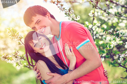 Image of Young couple enjoying in blooming garden