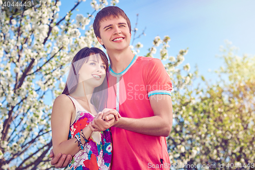 Image of Young couple enjoying in blooming garden