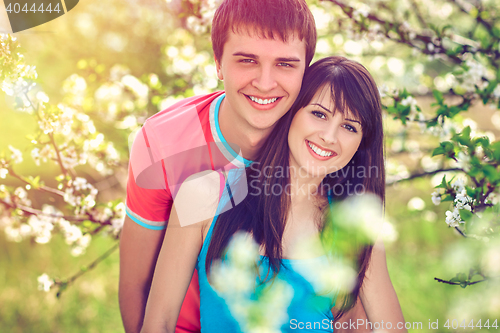 Image of Young couple enjoying in blooming garden