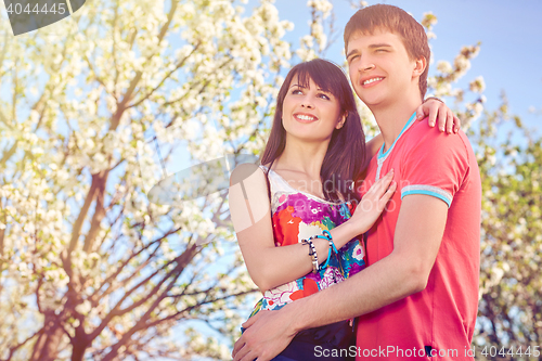 Image of Young couple enjoying in blooming garden
