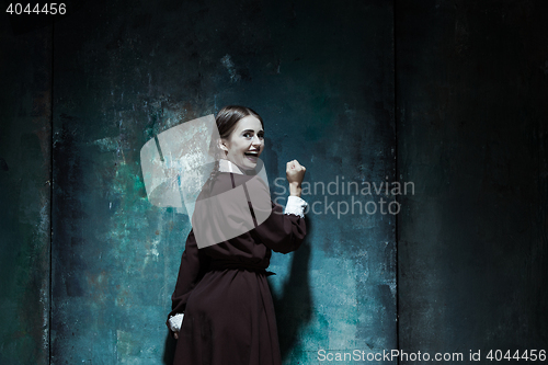 Image of Portrait of a young smiling girl in school uniform as killer woman