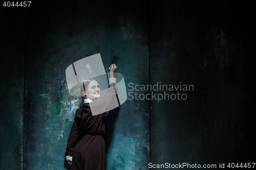 Image of Portrait of a young smiling girl in school uniform as killer woman