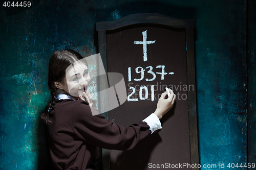 Image of Portrait of a young smiling girl in school uniform as killer woman