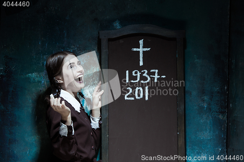 Image of Portrait of a young smiling girl in school uniform as killer woman