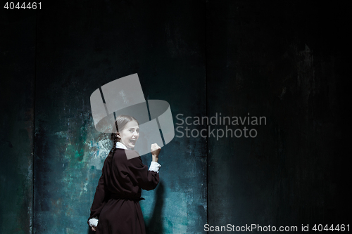 Image of Portrait of a young smiling girl in school uniform as killer woman