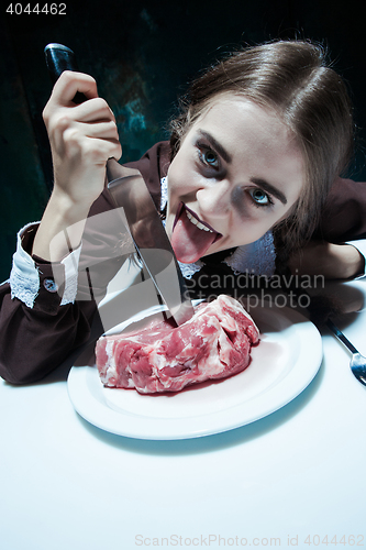 Image of Bloody Halloween theme: crazy girl with a knife and meat