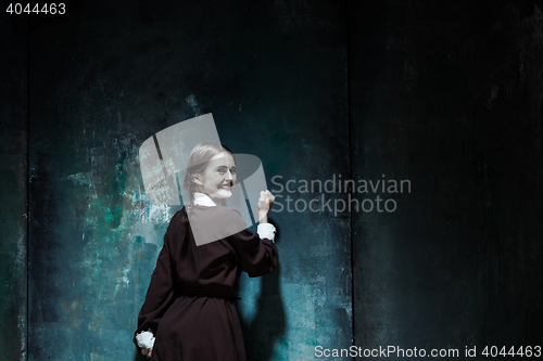 Image of Portrait of a young smiling girl in school uniform as killer woman