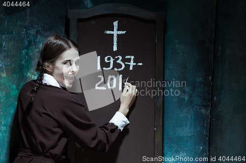 Image of Portrait of a young smiling girl in school uniform as killer woman