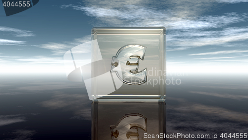 Image of euro symbol in glass cube under cloudy blue sky - 3d illustration