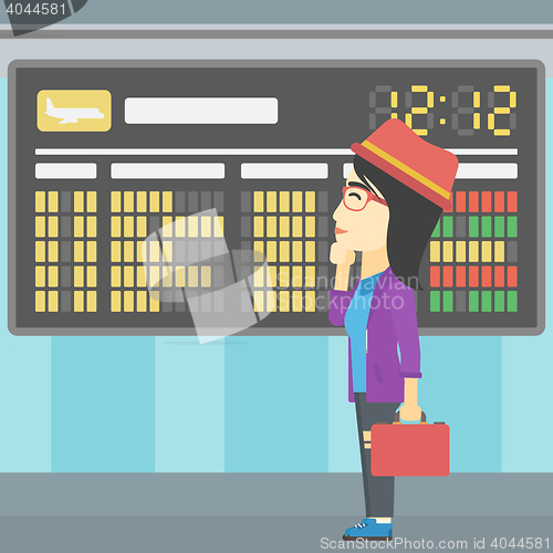 Image of Woman looking at schedule board in the airport.