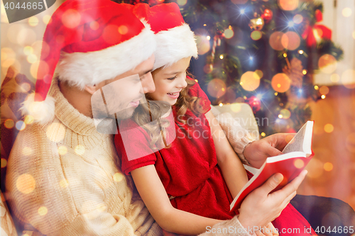 Image of smiling father and daughter reading book