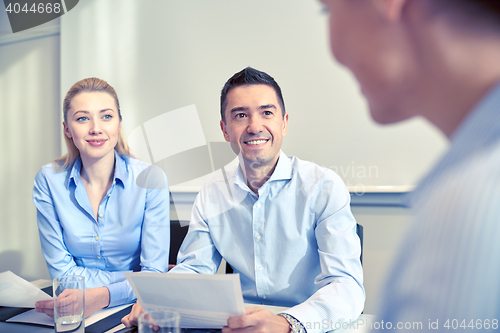 Image of group of smiling businesspeople meeting in office