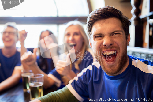 Image of football fans or friends with beer at sport bar