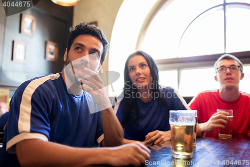 Image of fans or friends watching football at sport bar