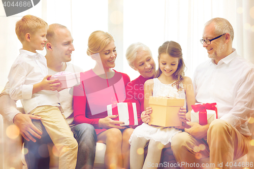 Image of smiling family with gifts at home