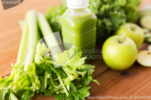 Image of close up of bottle with green juice and vegetables