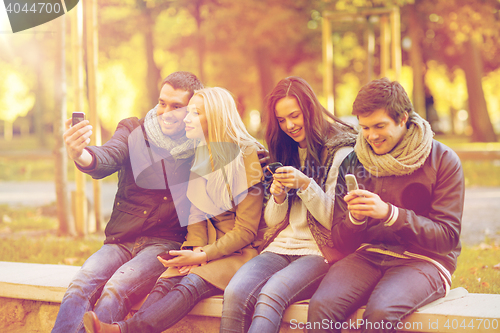 Image of group of friends having fun in autumn park