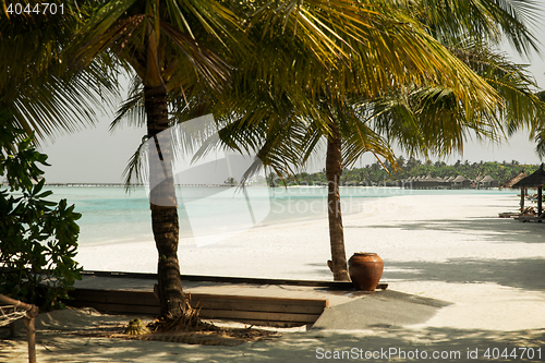 Image of bungalow huts in sea water on exotic resort beach