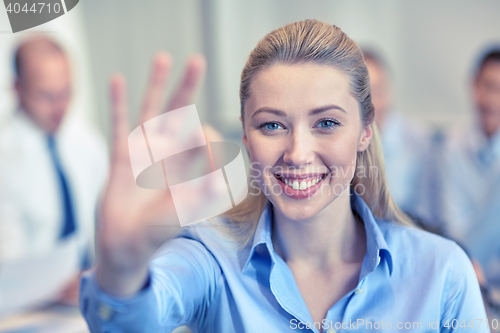 Image of group of smiling businesspeople meeting in office