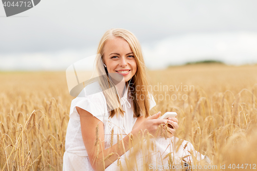 Image of happy woman with smartphone and earphones