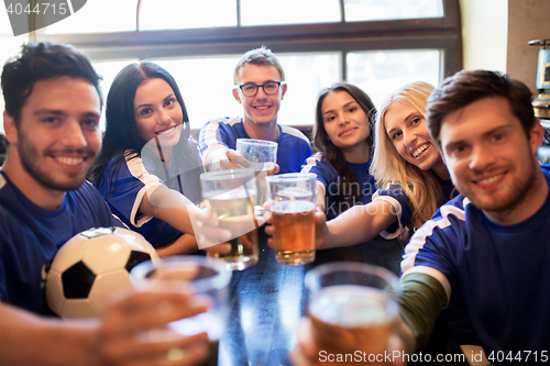 Image of football fans clinking beer glasses at sport bar