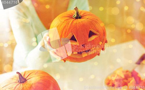 Image of close up of woman with pumpkins at home