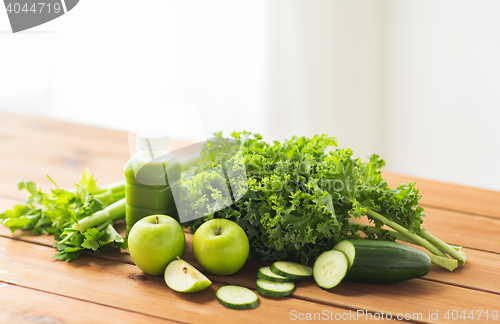 Image of close up of bottle with green juice and vegetables