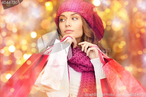 Image of happy woman in winter clothes with shopping bags