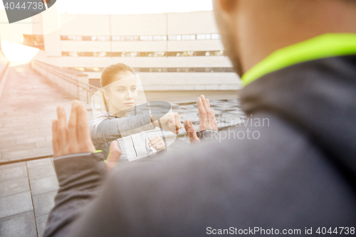 Image of woman with trainer working out self defense strike