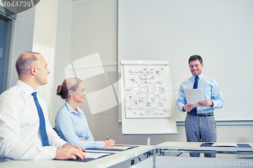 Image of group of smiling businesspeople meeting in office