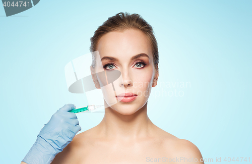 Image of woman face and hand with syringe making injection